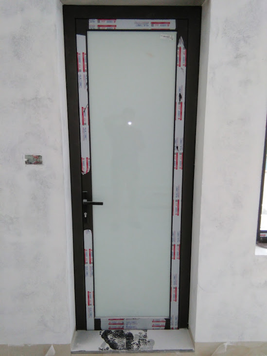 Cửa kính cường lực khung nhôm màu đen đang lắp đặt trong nhà